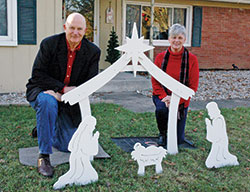 Jim Liston and Karen Smith pose in front of a Nativity scene in Indianapolis. (Photo by John Shaughnessy)