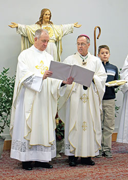 Father Michael Fritsch, left, pastor of Mary, Queen of Peace Parish in Danville, assists Archbishop Charles C. Thompson as the archbishop recites a prayer on Nov. 21 before blessing a newly constructed narthex, parish office and religious education wing at the parish. (Submitted photo courtesy of Betty Bartley, The Republican Newspaper)