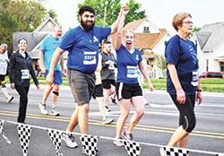 Shoaibullah and Lindsey Rasouli, members of St. John the Evangelist Parish in Indianapolis who were engaged at the time, take part in the then-Finish Line 500 Festival 5K in 2016 as part of the Race for Vocations team. The team is back to full in-person participation this year after having no event in 2020 and a limited event in 2021 due to the coronavirus pandemic. (Submitted photo)