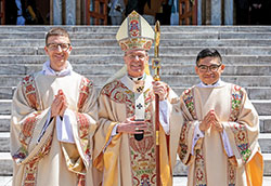 Transitional Deacon Jack Wright, left, and transitional Deacon Jose Neri pose on April 23 with Archbishop Charles C. Thompson outside the Archabbey Church of Our Lady of Einsiedeln in St. Meinrad. Archbishop Thompson ordained the two archdiocesan seminarians as deacons during a Mass in the church that day. (Photo courtesy of Saint Meinrad Archabbey)