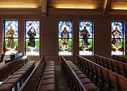 St. Toribio Romo, left, Mother Theresa Hackelmeier, St. Kateri Tekakwitha, St. Martin de Porres and St. Pope John Paul II are portrayed in the new stained-glass windows in the St. Joseph Chapel of Marian University in Indianapolis. (Submitted photo)