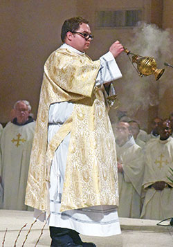 Transitional Deacon Matthew Perronie uses incense during the archdiocesan chrism Mass on April 12 at SS. Peter and Paul Cathedral in Indianapolis. A member of St. Malachy Parish in Brownburg, he and transitional Deacon Michael Clawson will be ordained to the priesthood by Archbishop Charles C. Thompson at the cathedral on June 4. (File photo by Sean Gallagher)