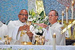 Deacon Oliver Jackson, left, and Archbishop Charles C. Thompson elevate the Eucharist during an Aug. 3, 2019, Mass at St. Rita Church in Indianapolis to celebrate the 100th anniversary of the founding of St. Rita Parish, a faith community founded to serve Black Catholics. (File photo by Sean Gallagher)