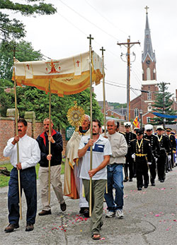 Franciscan Father Frank Jasper leads members of Holy Family Parish in Oldenburg on May 24, 2006, in a Corpus Christi procession. The Batesville deanery faith community has had held such processions annually since 1846. (File photo by Mary Ann Garber)