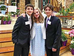 Gayle Blackburn poses with her twin grandsons Vincent, left, and Carmine Gioconda, after the Easter Vigil Mass at which all three received the sacrament of confirmation on April 16 at St. Malachy Church in Brownsburg. Blackburn also received the sacraments of baptism and the Eucharist. (Submitted photo)