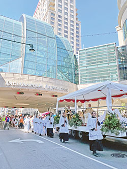 Catholics from across central and southern Indiana follow a float carrying the Blessed Sacrament during a June 19 eucharistic procession on Illinois Street in downtown Indianapolis. The procession was part of the start of the National Eucharistic Revival in the archdiocese. (Photo courtesy of Cantaloupe.tv)