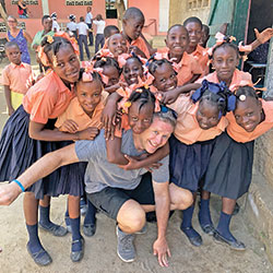 During a mission trip, David Siler shares a moment of joy with children who are students at the school of St. Mary Who Unties Knots Parish in Haiti, the twinning parish of St. Matthew the Apostle Parish in Indianapolis, where Siler is a member. (Submitted photo)
