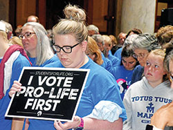 A pro-life advocate prays during a “Love Them Both” rally sponsored by Indiana Right to Life on July 26 at the Indiana Statehouse in Indianapolis. The rally took place while an Indiana Senate committee was preparing to vote on a bill that would ban most abortions in the state. (File photo by Sean Gallagher)