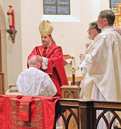 Bishop Steven J. Lopes ritually lays hands on deacon candidate Lee Ashton on Aug. 10 at Our Lady of Walsingham Cathedral in Houston during a Mass in which Ashton was ordained permanent deacons for the Ordinariate of the Chair of St. Peter. (Submitted photo)