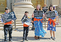 Daniel Hernandez, Jr., left, his brother David, their sister Sara Cabrera, far right, and her friend Olivia Murrey, all members of St. Thomas More Parish in Mooresville, proclaim their support for life outside SS. Peter and Paul Cathedral in Indianapolis during the Life Chain event following the Respect Life Sunday Mass at the cathedral on Oct. 2. (Photo by Natalie Hoefer)