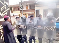 Bishop Rolando Álvarez of Matagalpa, Nicaragua, is pictured in a screenshot from video at his residence in Matagalpa as riot police block the door. The police kept him and a group of priests, seminarians and lay Catholics under house arrest for about two weeks until Aug. 19 when the police seized them in a pre-dawn raid and took them in custody to Managua. 
(CNS screenshot/YouTube)