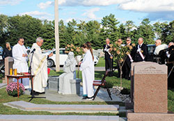 Father John Meyer, pastor of St. Mary Parish in Greensburg, blesses a statue at the Little Souls Cemetery dedication Mass on Sept. 27. Also pictured is Deacon Brad Anderson. second from left, and altar servers Clare and Cecilia Scheidler (partially obscured). The Little Souls Cemetery is part of St. Mary Cemetery in Greensburg. (Submitted photo by Jennifer Lindberg)