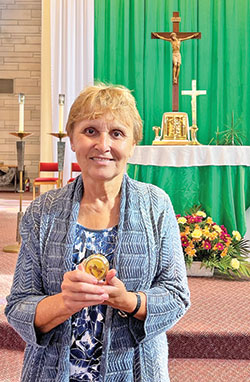 As an extraordinary minister of holy Communion, Marianne Warthan of St. Paul Catholic Center in Bloomington believes her ministry is “the most rewarding one in the Church.” She displays a pyx, which holds Communion taken to sick and homebound Catholics. (Submitted photo)