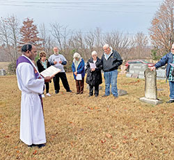 Father Jeyaseelan “Jey” Sengolraj, administrator of St. Francis Xavier Parish in Henryville, leads a prayer in the parish’s cemetery on Nov. 2, All Souls’ Day. (Submitted photo)