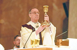 Archbishop Charles C. Thompson raises a chalice on April 12 in SS. Peter and Paul Cathedral in Indianapolis during the annual archdiocesan chrism Mass. The bishops of the U.S. recently elected Archbishop Thompson chairman-elect of their Committee on Evangelization and Catechesis, which oversees the National Eucharistic Revival and the National Eucharistic Congress to be held in Indianapolis in July 2024. (File photo by Sean Gallagher)