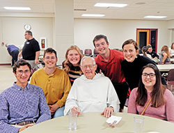Dominican Father Justus Pokrzewinski enjoys spending time with students on Oct. 16 during a Sunday evening meal at St. Paul Catholic Center on the campus of Indiana University in Bloomington. Pictured, seated, from left, are Jose Kaufmann, Father Justus and Abigail Cerimele. Behind them, from left, are Connor Gorton, Lizzy Hart, Dane Babillis and Elizabeth White. (Photo by Mike Krokos)