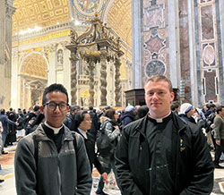 Archdiocesan seminarians Khaing Thu, left, and Samuel Hansen stand on Jan. 3 in St. Peter’s Basilica at the Vatican after praying before the mortal remains of Pope Benedict XVI. (Submitted photo)
