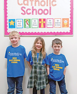 Walter Chandler, left, Gemma Karpinski and John Verspelt sport T-shirts showing their celebration of Christ the King School in Indianapolis being named a 2022 national Blue Ribbon School by the U.S. Department of Education. (Submitted photo)