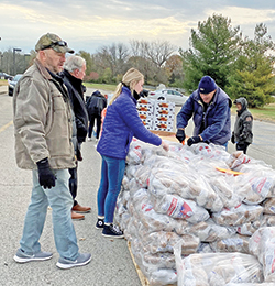 As the agency director of Catholic Charities Terre Haute, John Etling, left, has always been hands-on in bringing food, hope and dignity to people in need. (Submitted photo)