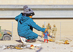 A migrant boy, who is traveling with his family to seek asylum in the United States, plays with a Captain America action figure along the border between Mexico and the United States in Ciudad Juárez, Mexico, on Dec. 27, 2022. Some families in the Archdiocese of Indianapolis have welcomed unaccompanied children at the border into their homes, serving as short-term foster parents for the children who hope to be reunited with their parents and other family members in the United States. (CNS photo/Jose Luis Gonzalez, Reuters)