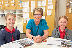 In her 38 years of teaching at Catholic schools in the archdiocese, Sally Meyer has always tried to share the gift of her faith and her gifts as a teacher with her students. Here, the sixth-grade teacher at St. Jude School in Indianapolis poses for a photo with two of her students, Macy Tilson, left, and Josephine Clark. (Submitted photo)