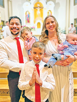 Kelvin and Mary Jimenez are all smiles as they celebrate Kelvin and their 8-year-old son Lucas receiving their first Communion together at an Easter Vigil Mass at the St. Martin campus of All Saints Parish in Dearborn County—a moment also shared with their 2-year-old son Nicodemus and their 6-month-old son Raphael. (Submitted photo)