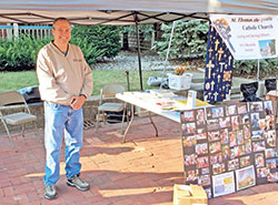 Kevin Brady, a member of St. Thomas the Apostle Parish in Fortville, mans a booth for the Indianapolis East Deanery faith community at an ecumenical event in the town in northwestern Hancock County. (Submitted photo)