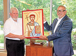 Deacon Michael East, left, and Deacon David Bartolowits pose with an icon of St. Lawrence on Aug. 6 during a dinner for archdiocesan deacons at Our Lady of Fatima Retreat House in Indianapolis. The icon was a gift to Deacon East who had retired the previous month after 12 years of service as archdiocesan director of deacons. (Photo by Sean Gallagher)