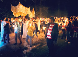 Father Michael Keucher carries the Blessed Sacrament during a eucharistic procession on the evening of Sept. 16 during the archdiocesan Family Camp. (Submitted photo by Felix Navarrete)