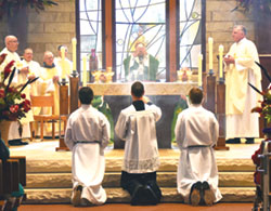 Archbishop Charles C. Thompson elevates the Eucharist during a 200th parish anniversary Mass at St. Mary-of-the-Knobs Church in Floyd County on Oct. 15. Concelebrating with him are Father Michael Hilderbrand, left, Father Stephen Banet, Conventual Franciscan Father John Elmer and Father Steven Schaftlein. Father William Marks, the parish’s current pastor, is at right. (Photo by Natalie Hoefer)