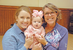Katie Tipker, left, her daughter Eden and her mother Becky Kruer share a joyful generational moment. As the director of discipleship for St. John Paul II Parish in Sellersburg, Tipker will lead a youth group to the National Catholic Youth Conference in Indianapolis on Nov. 16-18. (Photo by John Shaughnessy)