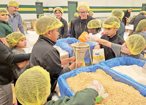 Students and staff of Holy Spirit School in Indianapolis prepare pre-packaged meals for Indianapolis-based Million Meal Movement in the school’s gym on Nov. 19, 2024. (Submitted photo)