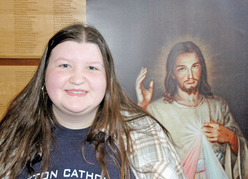Landry Cox, a senior at Seton Catholic High School in Richmond, poses for a photo next to an image of Christ before a Mass that Archbishop Charles C. Thompson celebrated for high school seniors from across the archdiocese at St. Malachy Church in Brownsburg on Dec. 4. (Photo by John Shaughnessy)