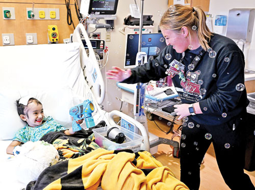 As this interaction shows, Anna Lubbers tries to add a touch of joy to the lives of the children she cares for as a registered nurse at Riley Hospital for Children in Indianapolis. (Photo courtesy of Mike Dickbernd)