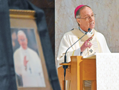 With a framed portrait of Pope Francis in the foreground, Archbishop Charles C. Thompson delivers a homily during a Mass for the late pope on April 24 in SS. Peter and Paul Cathedral in Indianapolis. (Photo by Natalie Hoefer)