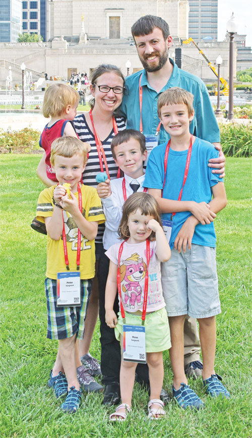 Leigh and Benjamin Sargeant and their five children—Rose in front, with Peter, left, Dominic and Samuel behind her, and Isaiah, held by Leigh—serve as an image of the family as a “domestic Church” as they pose in Memorial Plaza in Indianapolis on July 20, 2024, after adoration there during the National Eucharistic Congress. (File photo by Natalie Hoefer)