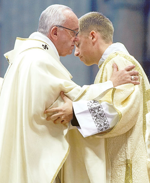 Pope Francis and then-transitional Deacon Anthony Hollowell exchange a sign of peace on March 19, 2016, during a Mass at St. Peter’s Basilica at the Vatican. (Submitted photo)