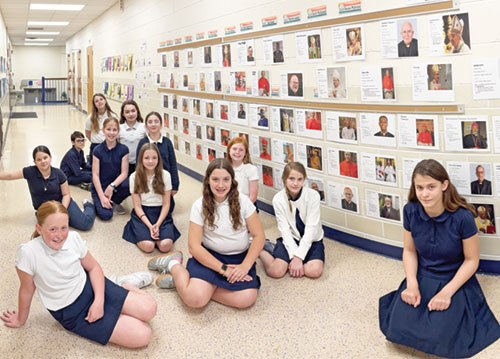Students at St. Michael School in Greenfield sit in the hallways where they posted the results of their in-depth study analyzing the cardinals taking part in the papal conclave. (Submitted photo)