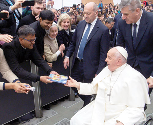 Father Sengole Thomas Gnanaraj, pastor of St. Elizabeth Ann Seton Parish in Richmond, gives two books he wrote to Pope Francis after a Feb. 7, 2024, general audience at the Vatican. (Submitted photo)