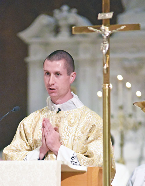 Transitional Deacon Isaac Siefker proclaims the Gospel during the annual archdiocesan chrism Mass on April 15 at SS. Peter and Paul Cathedral. (Photo by Sean Gallagher)