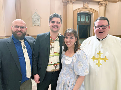 Isaiah Doss, second from left, and Hannah Carroll smile with Michael Valenti, at left, and Father James Brockmeier after the Easter Vigil Mass at SS. Peter and Paul Cathedral in Indianapolis on April 19, during which Doss and Carroll were welcomed into the full communion of the Church. Both were introduced to the Catholic faith by Valenti, who served as Carroll’s sponsor. Father Brockmeier is rector of SS. Peter and Paul Cathedral Parish. (Submitted photo)