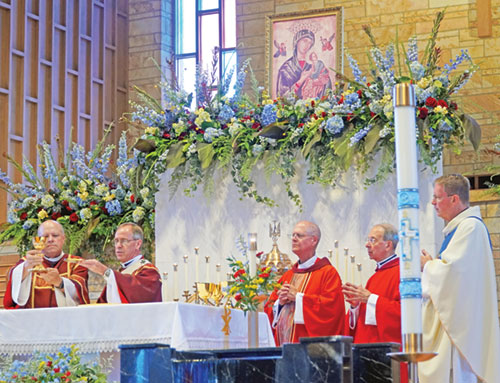 Deacon Jeffrey Powell, left, and Archbishop Charles C. Thompson elevate the Eucharist during the 75th anniversary Mass on June 28 for Our Lady of Perpetual Help Parish in New Albany. Also pictured are Seattle Archbishop Paul D. Etienne, middle, Baltimore Archbishop William E. Lori, second from right, and Father Joseph Feltz, pastor of Our Lady of Perpetual Help Parish. (Submitted photo by Olivia Castlen)