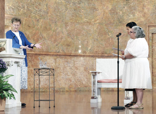Providence Sister Dawn Tomaszewski, general superior of the Sisters of Providence of Saint Mary-of-the-Woods in St. Mary-of-the-Woods, left, welcomes Ann Duong, second from right, and Maité Rodriguez-Mora as novices in the community during an Aug. 24 ceremony in the Church of the Immaculate Conception at the community’s motherhouse. (Submitted photo)