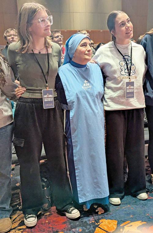 Grace Fischer, a chaperone from the Diocese of Fort Wayne-South Bend, left, and Kendall Schreck, a student at Bishop Dwenger High School in Fort Wayne, Ind., right, stand with Mother Olga of the Sacred Heart at the end of the Indiana Youth Rally for Life on Jan. 22 at the Indiana Convention Center in Indianapolis. Mother Olga was the keynote speaker at the rally. (Photos by Sean Gallagher)