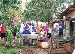 Members of a mission group sponsored by St. Thomas Aquinas Parish in West Lafayette speak with a Cuban woman at her home, where she cares for a severely handicapped young boy. (Photo courtesy Matt McKillip)