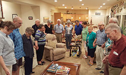 Members of the Basic Christian Community join hands for closing prayer at a recent gathering at the home of Rafik and Patricia Bishara in Carmel. Community members include Jayne and Dick Moore, Janet and Rich Warns, Barb and Bob Dykstra, Judy and Tom Steiner, Ruth and Tom Kueper, Eileen and Kent Champagne, Pat Boynton and the Bisharas. (Photo by Brigid Curtis Ayer)