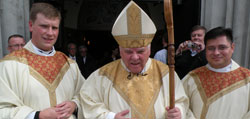 Father Jacob Runyon, left, and Father Fernando Jimenez, right, pose with Bishop John M. D’Arcy on the steps of the Cathedral of the Immaculate Conception in Fort Wayne after their ordination to the holy priesthood on Saturday, Oct. 31.