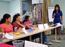 Acuzena Dubon, Tita Prado and Chuyita Prado listen as Maura Robinson talks about the Latino culture, its customs, rituals, social structure, needs and concerns during a June 19 workshop at the Guadalupe Center in Huntingburg.