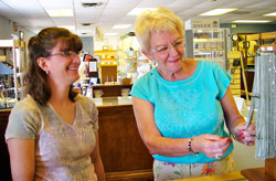 Kimberly Marsh and Mary Winnecke look at merchandise at the Cornerstone, a Catholic bookstore in Evansville. Kimberly is the store manager, and Mary is a sales associate. (Message photo by Mary Ann Hughes)