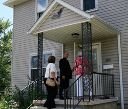 Bishop Kevin C. Rhoades joins Vincent Village Executive Director Ann Helmke, right, and board member Marian Welling on a tour of the renovated houses of Vincent Village on July 30.